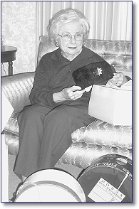 Anne Edmonds selects a hat from the many hat boxes she has stored.